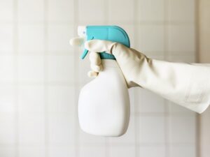 ゴム手袋をしてスプレーボトルを持つ手元