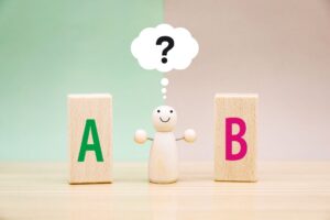 木製ブロックのAとBを見比べる人形の置物
